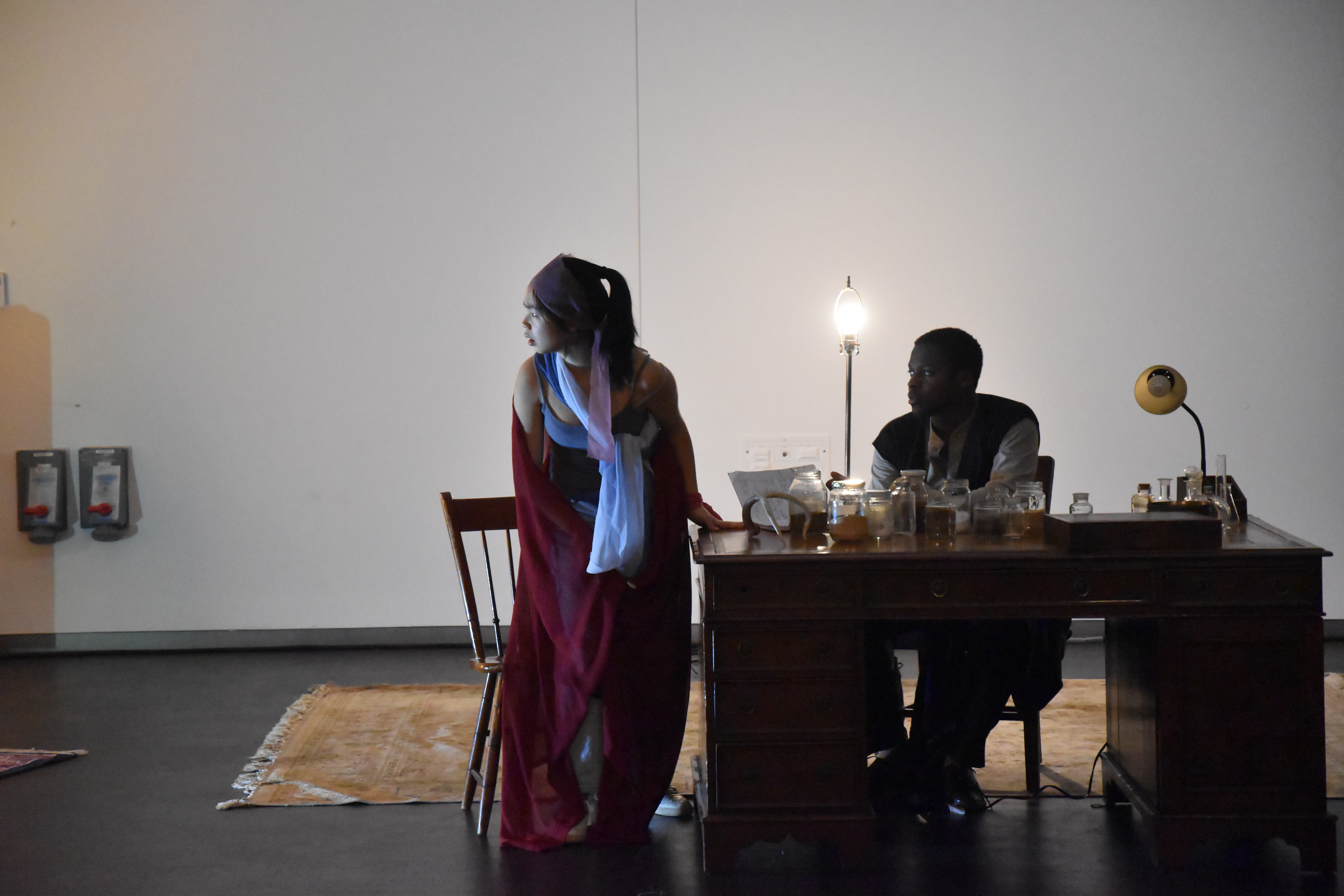 < A photograph from the Program in Theatre's 2019 production of Echoes in Glass  >